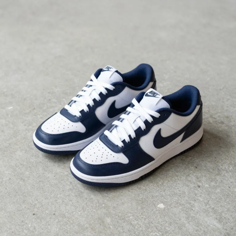 A pair of navy and white trainers with a swoosh, on a concrete floor