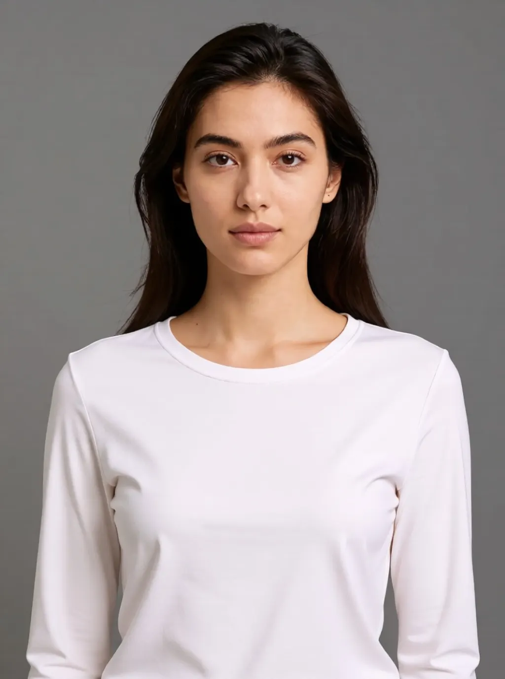 A woman in a crisp white top against a seamless grey studio backdrop
